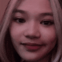 a close up of a woman 's face with a pink background and a blurred background .