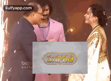 a man and a woman are standing next to each other in front of a sign that says ' malayalam ' on it .