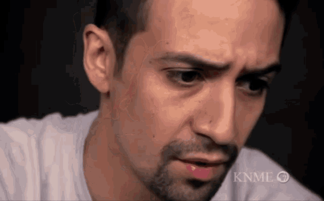 a close up of a man 's face with the words knme on the bottom