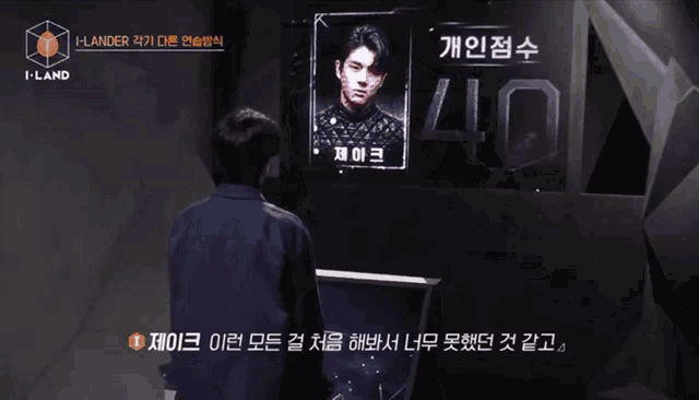 a man stands in front of a screen that says i-land on it