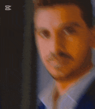 a close up of a man 's face with the letter u behind it