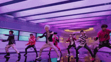 a group of young men are dancing in front of a sign that says dream on it