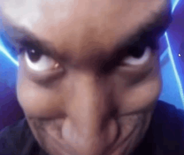 a close up of a person 's face making a funny face with a blue background .