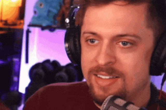 a man wearing headphones and a microphone looks at the camera