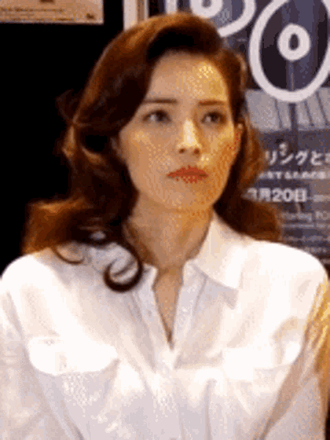 a woman wearing a white shirt and red lipstick