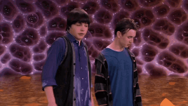 two boys are standing in front of a purple background with holes in it