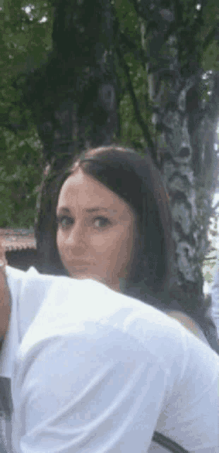a woman in a white shirt looks over a man 's back