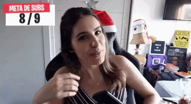 a woman is sitting in a chair in front of a sign that says meta de subs