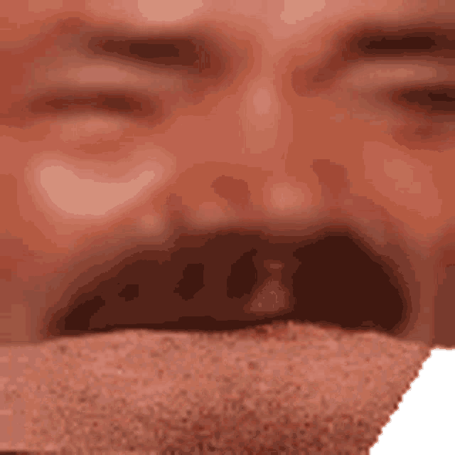 a close up of a man 's face with his mouth open and a piece of cake in his mouth .