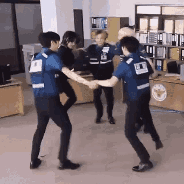 a group of police officers are dancing in a room .