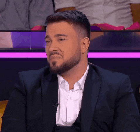 a man with a beard is wearing a suit and a white shirt .