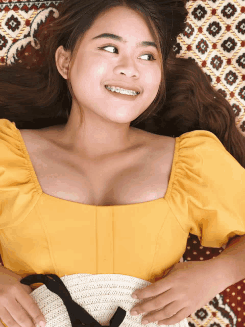 a woman with braces on her teeth is smiling while laying down