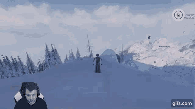a man is playing a video game while sitting in front of a mountain