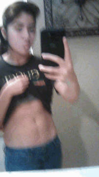 a man is taking a picture of himself in a mirror with a shirt that says g on it
