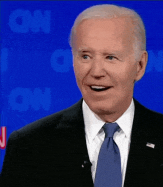a man in a suit and tie is smiling in front of a blue cnn background