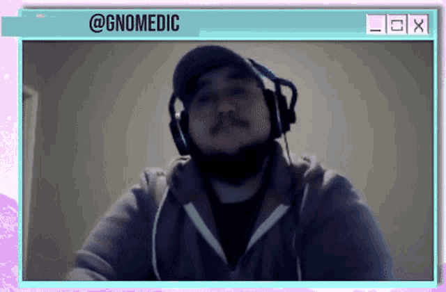 a man wearing headphones and a hat with the name @gnomedic on the bottom