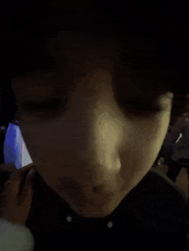 a blurry picture of a person 's face with a person 's hand covering it