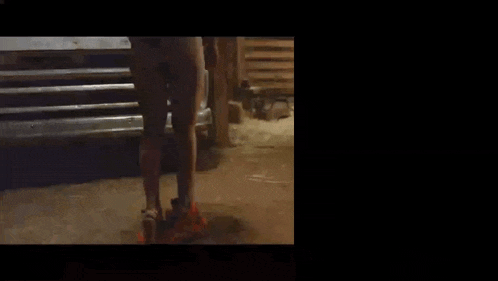 a woman in shorts is standing in front of a truck at night