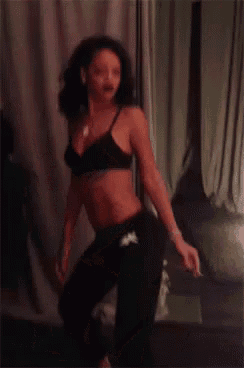 a woman in a black bra and black sweatpants is dancing
