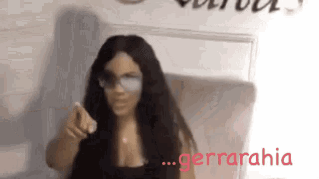 a woman wearing glasses is pointing at the camera and the word cerrahia is visible in red