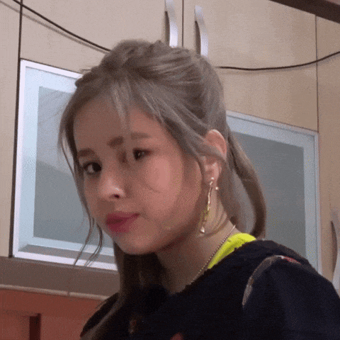a close up of a woman wearing earrings and a ponytail
