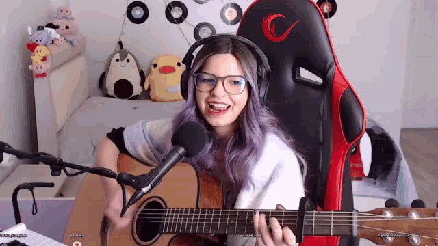 a woman wearing headphones and playing a guitar
