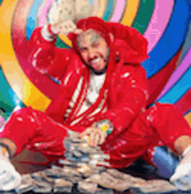 a man in a red suit is sitting on a pile of money