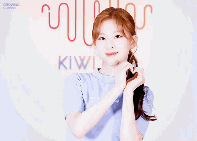 a girl making a heart shape with her hands in front of a sign that says growing up