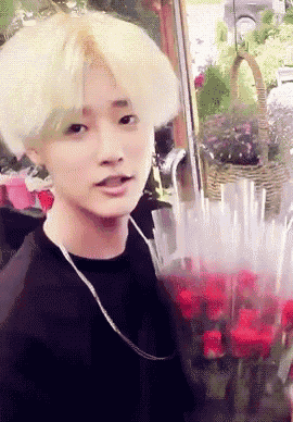 a young man holding a bouquet of red roses