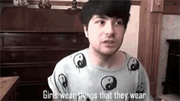 a man wearing a t-shirt that says `` girls wear things that they wear '' is talking to a camera .