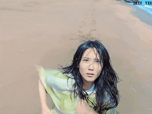 a girl in a green dress is standing in the water with the watermark drxx_yxh on the bottom