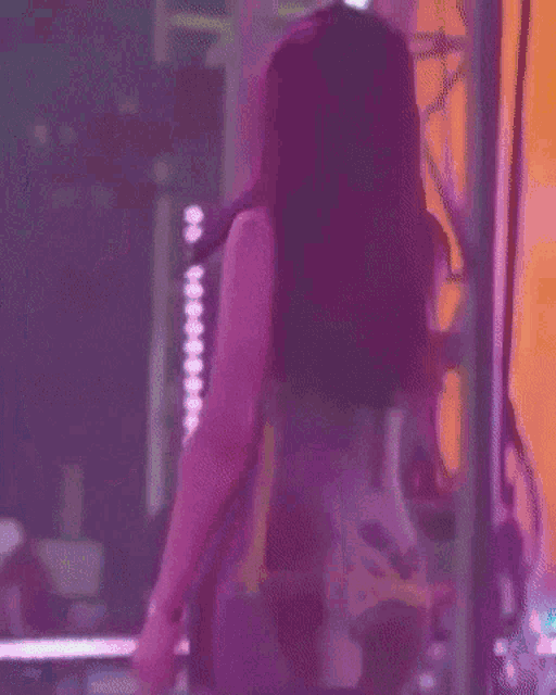a woman is singing into a microphone on a stage in front of a crowd .
