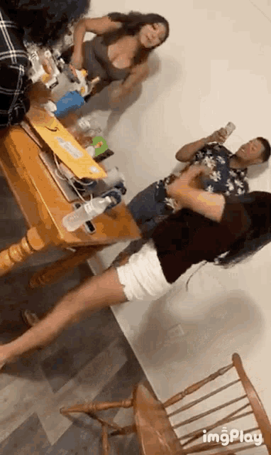 a group of people standing around a table with a gif that says imgplay in the corner