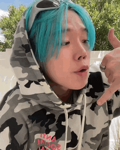 a person with blue hair is wearing a hoodie that says it 's a jador