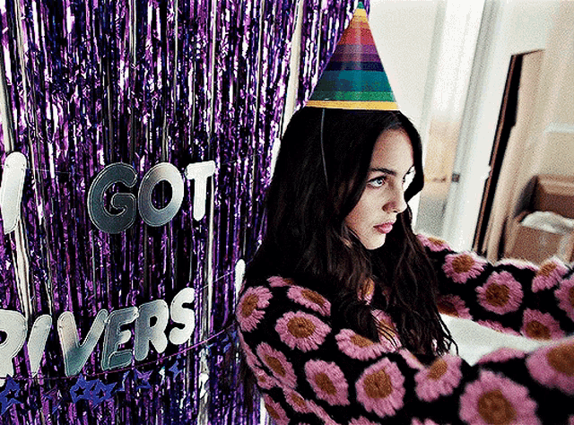 a woman wearing a party hat is taking a selfie in front of a sign that says " i got rivers "