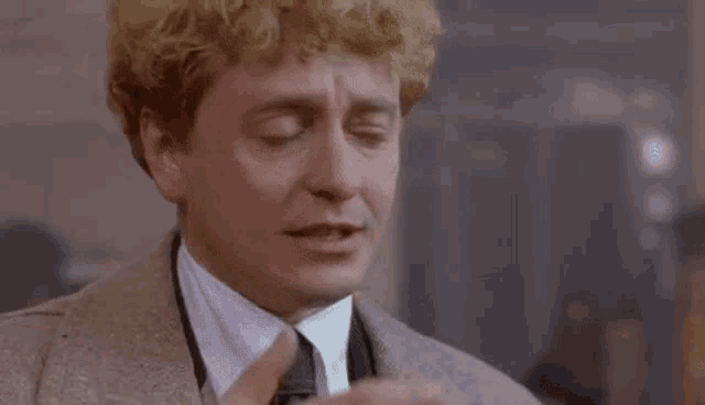 a man in a suit and tie is making a face .