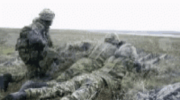 a blurry picture of a soldier laying on the ground .