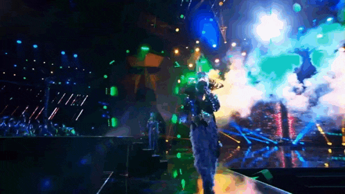 a man in a costume is singing into a microphone on stage