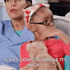 a woman and a little girl are sitting on a couch with a teddy bear . the girl is wearing glasses .