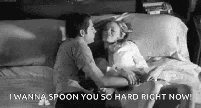 a man and a woman are kissing on a bed and the man is holding the woman 's head .