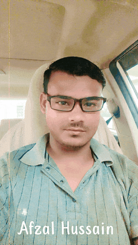 a man wearing glasses is sitting in a car with the name afzal hussain below him