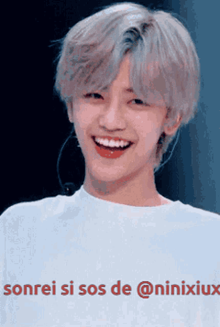 a young man wearing a white shirt with sonrei si sos de @ninixiux written on it