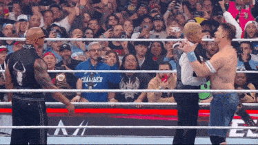 two wrestlers in a ring with one wearing a chamber shirt