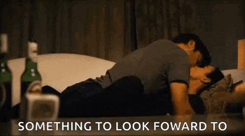a man and a woman are kissing on a couch with the words `` something to look forward to '' .