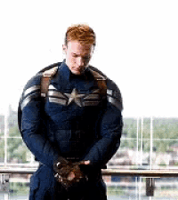a man in a captain america costume is standing next to a railing .