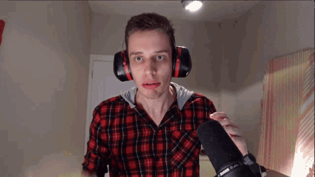 a man wearing headphones is holding a microphone