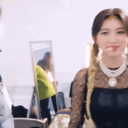 a woman is standing in front of a mirror with her tongue out