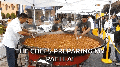 a group of men preparing paella in a large pan with the caption the chefs preparing my paella