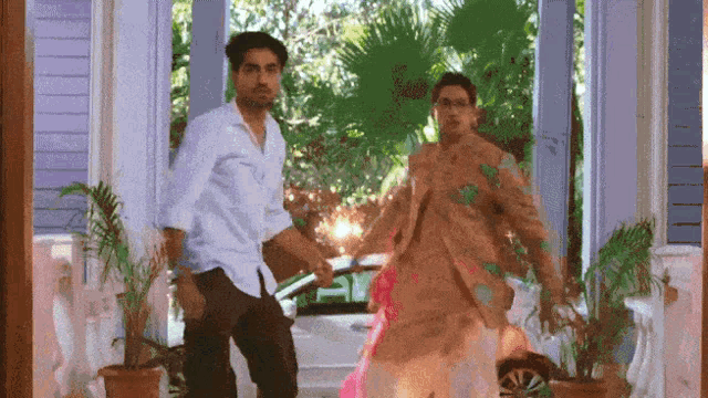 a man and woman are dancing on a porch holding hands