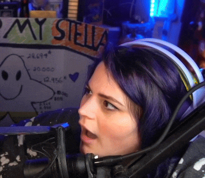 a woman with purple hair is wearing headphones in front of a sign that says " my stella "